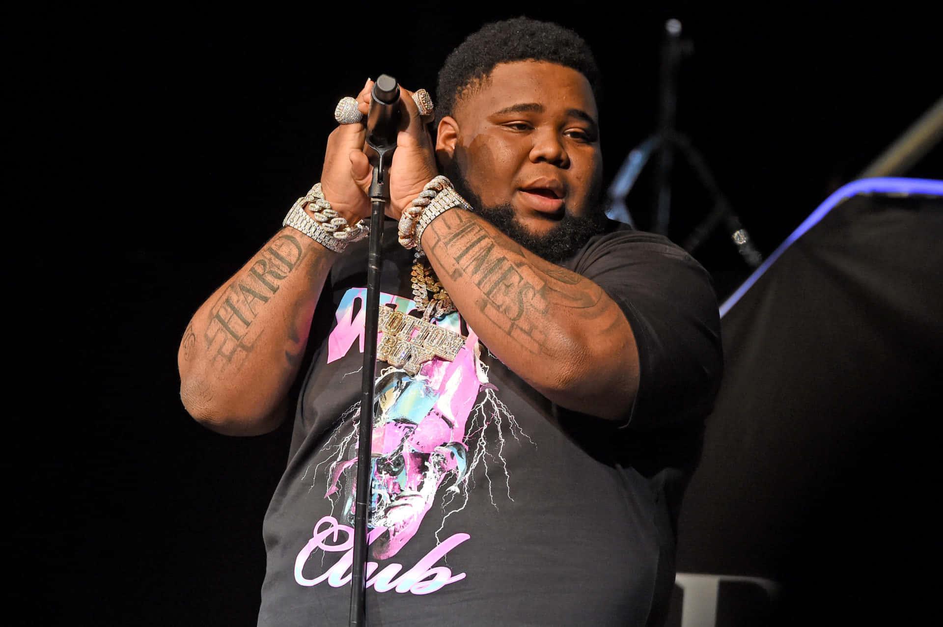 a man with tattoos on his arms is holding a microphone — 1920x1277 wallpaper