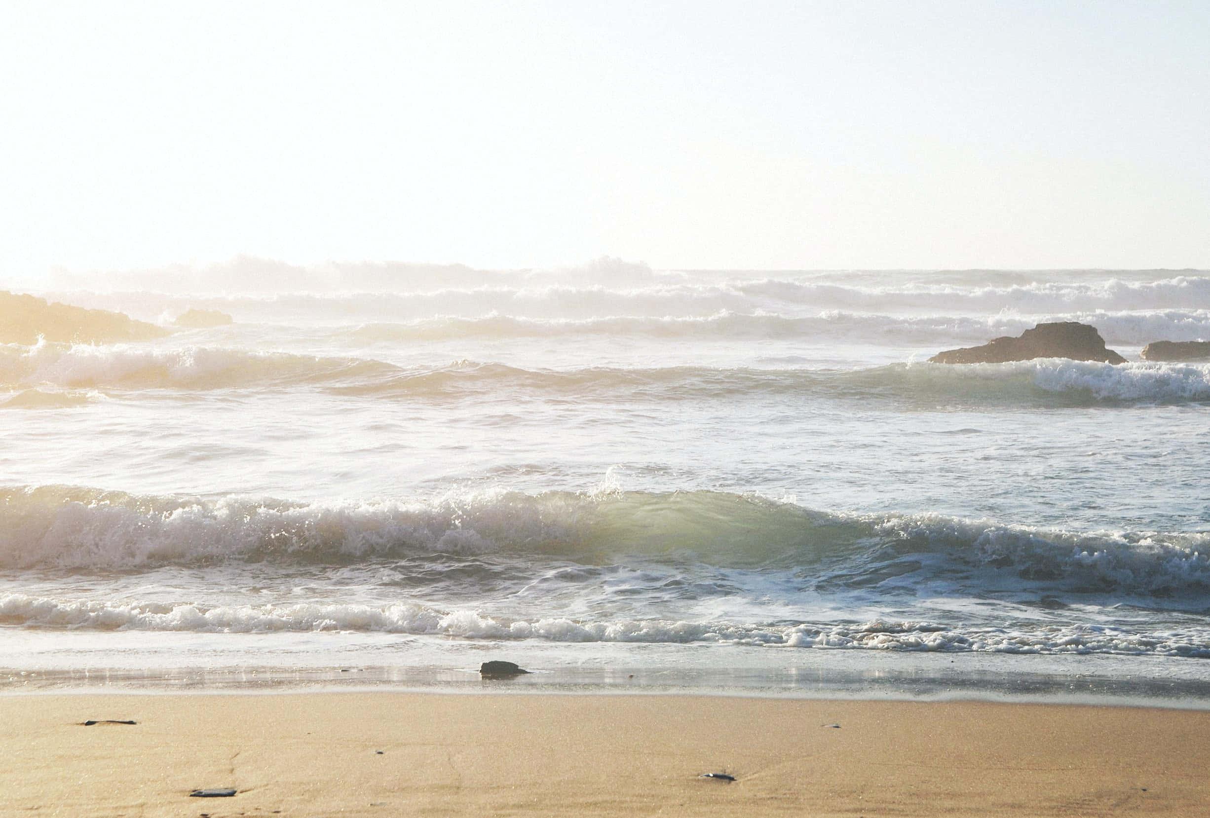 A peaceful beach day with the waves rolling in. — 2452x1658 wallpaper