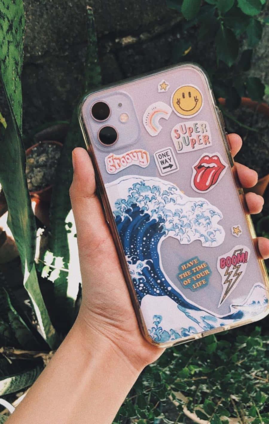 a person holding a phone case with stickers on it