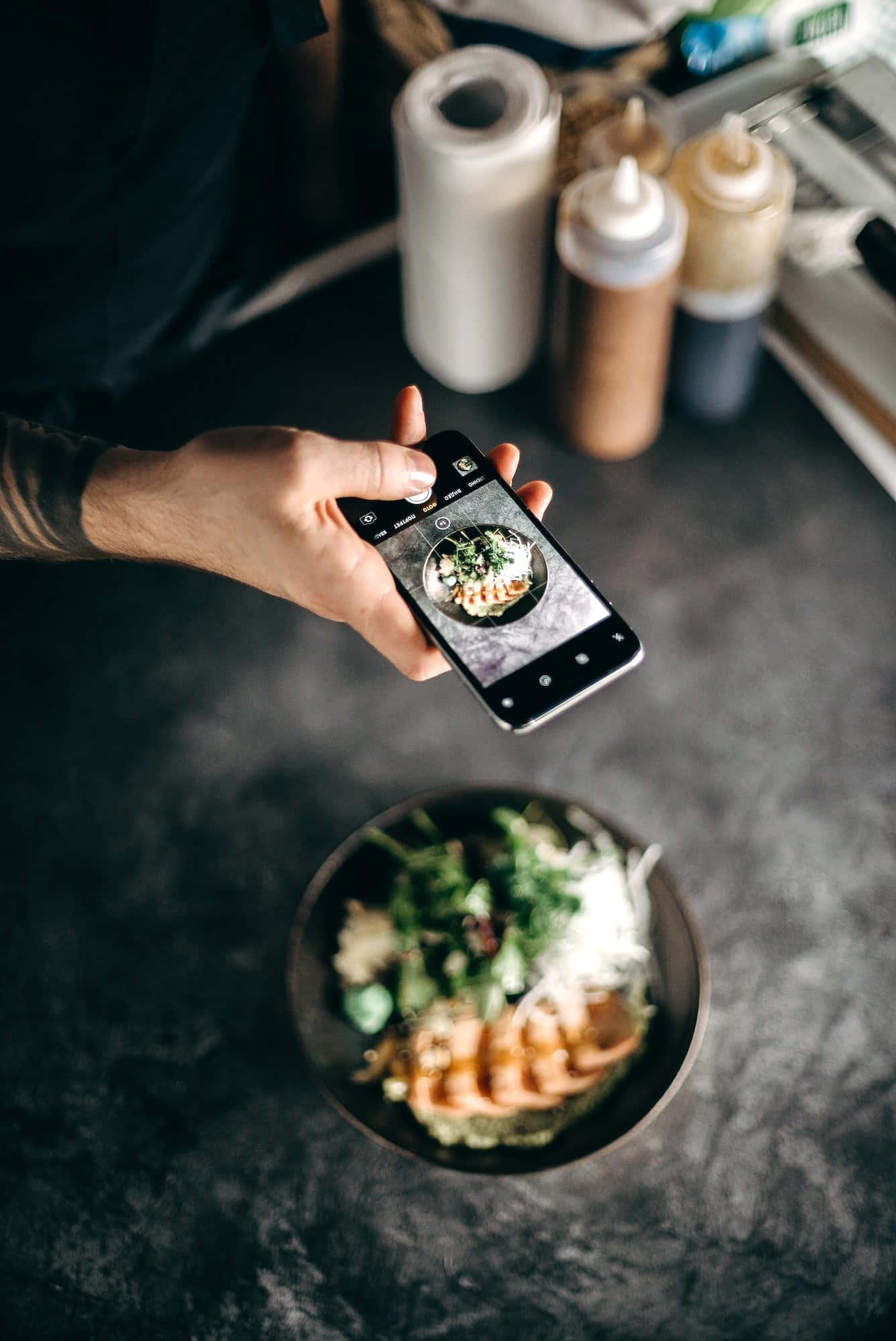 a person taking a photo of a food — 1336x2000 wallpaper