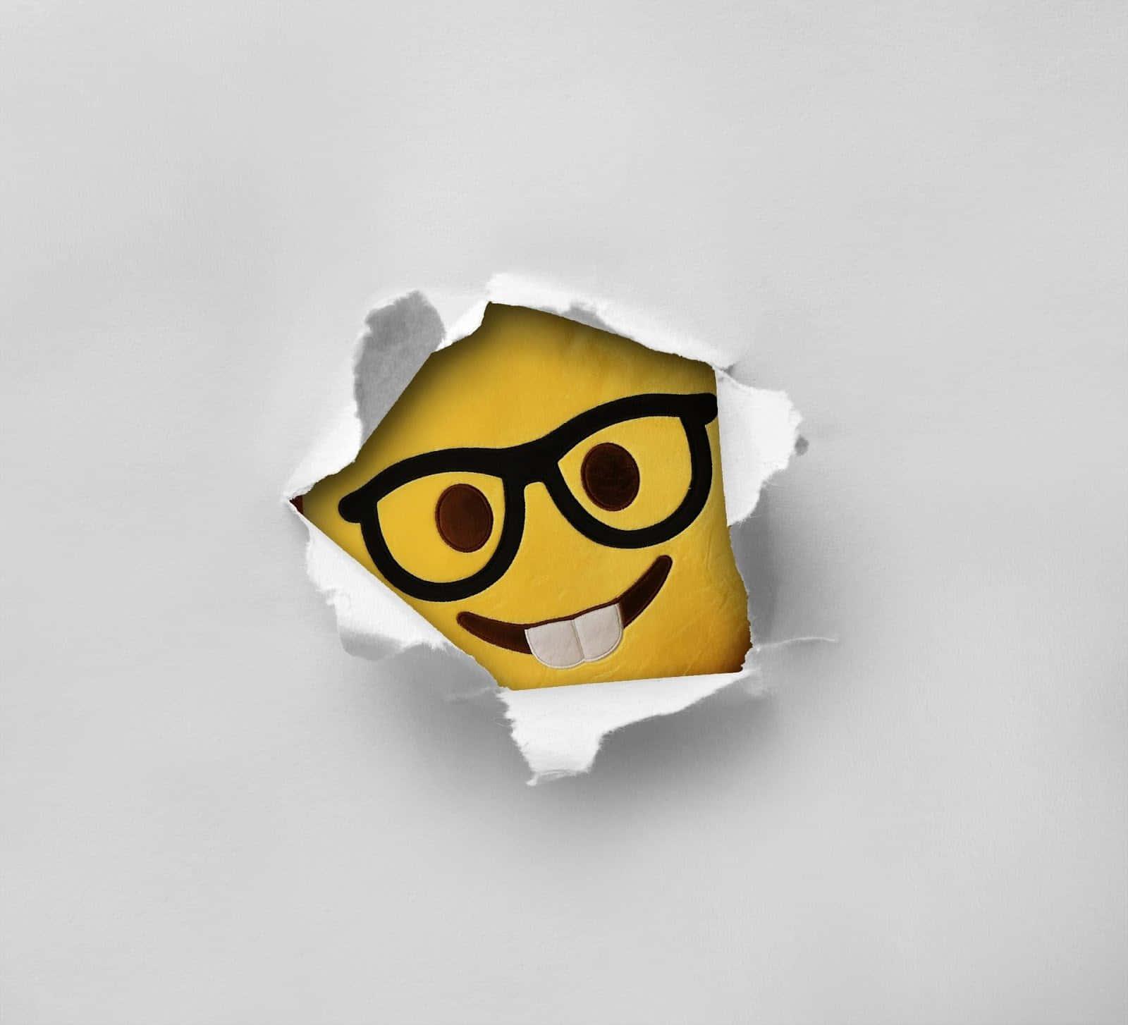 a smiling emoji face is peeking out of a piece of paper — 1600x1454 wallpaper