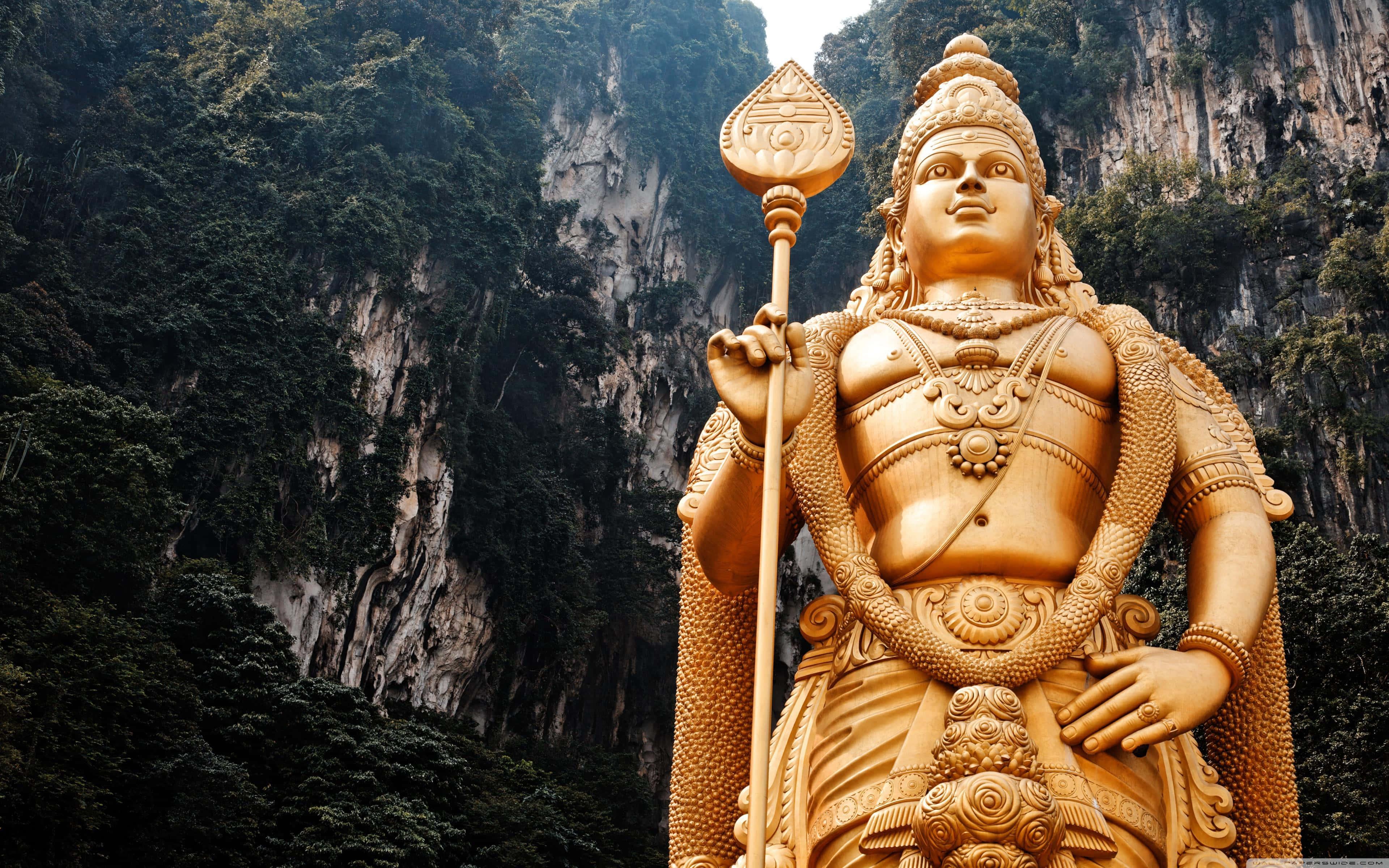 a statue of lord shiva in front of a mountain