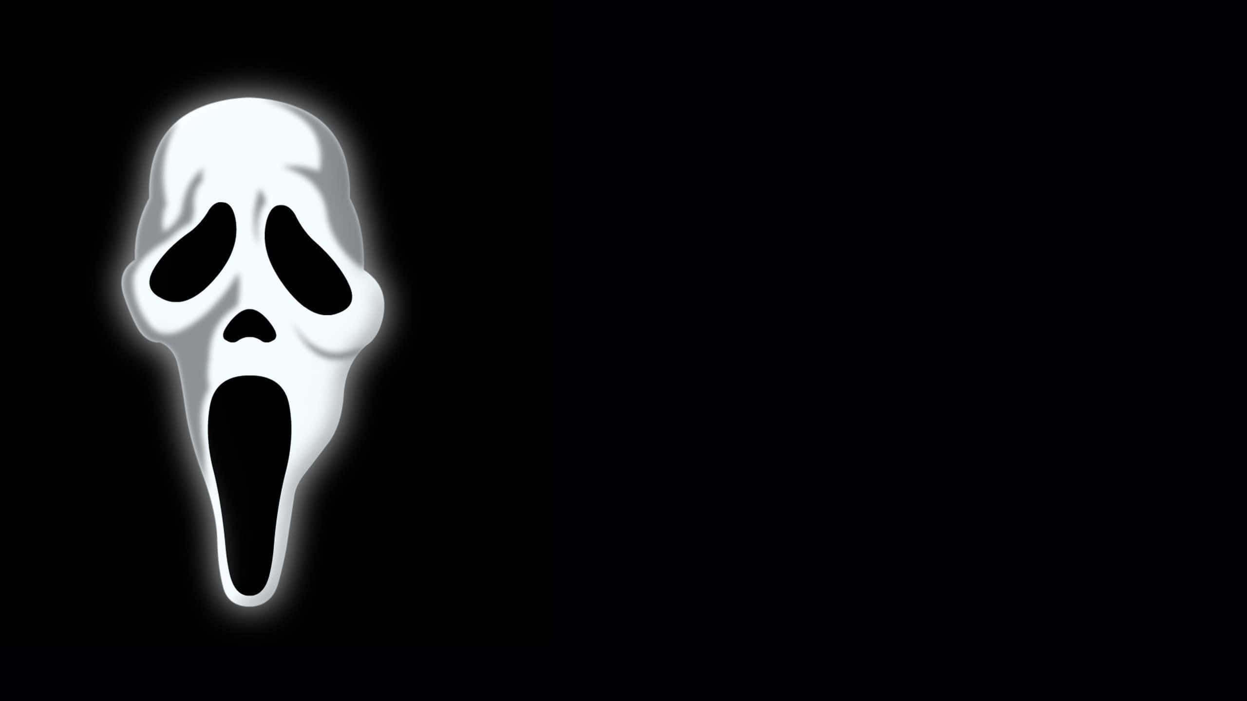 a white scream mask on a black background — 2560x1440 wallpaper