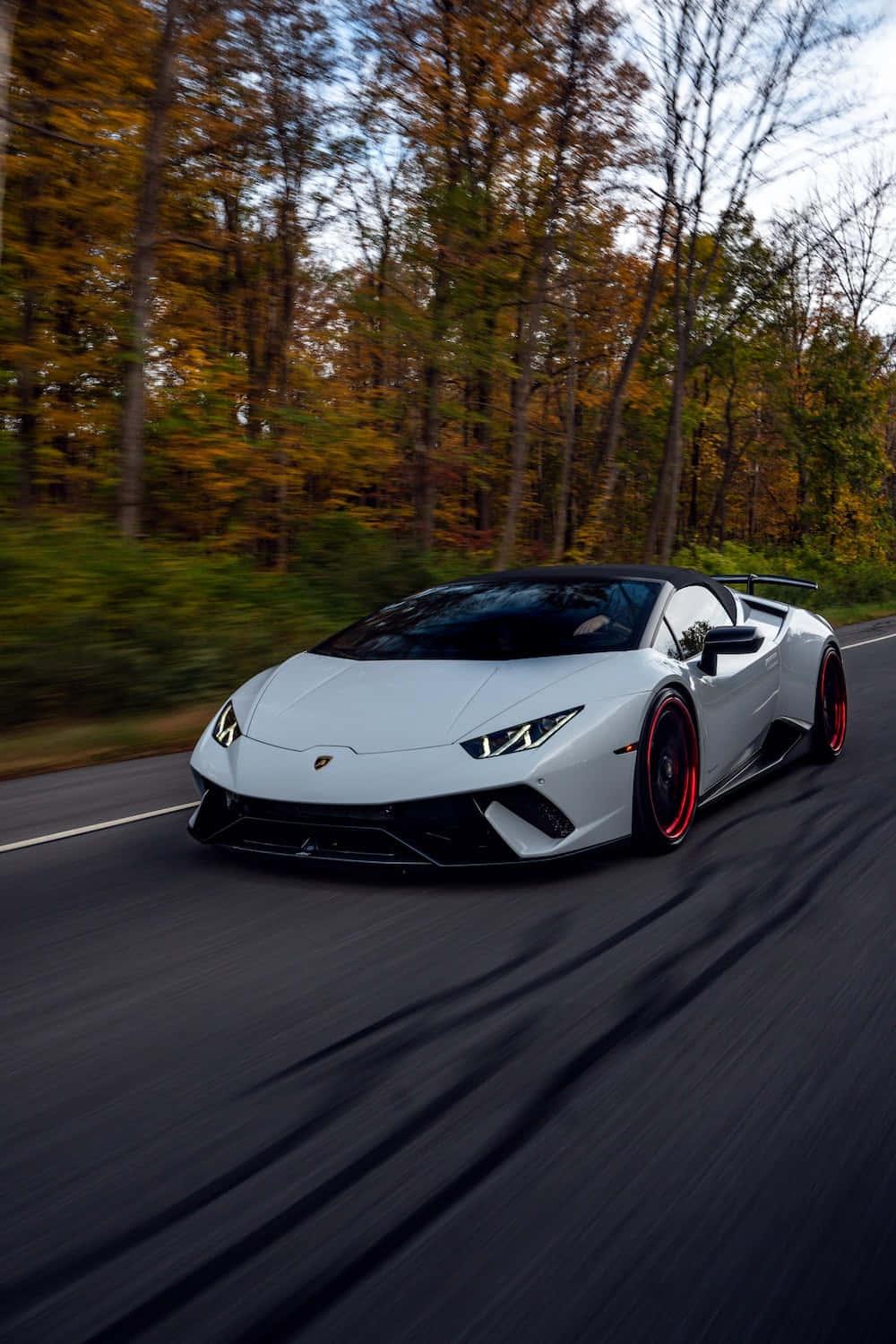 a white sports car driving down a road — 1000x1500 wallpaper