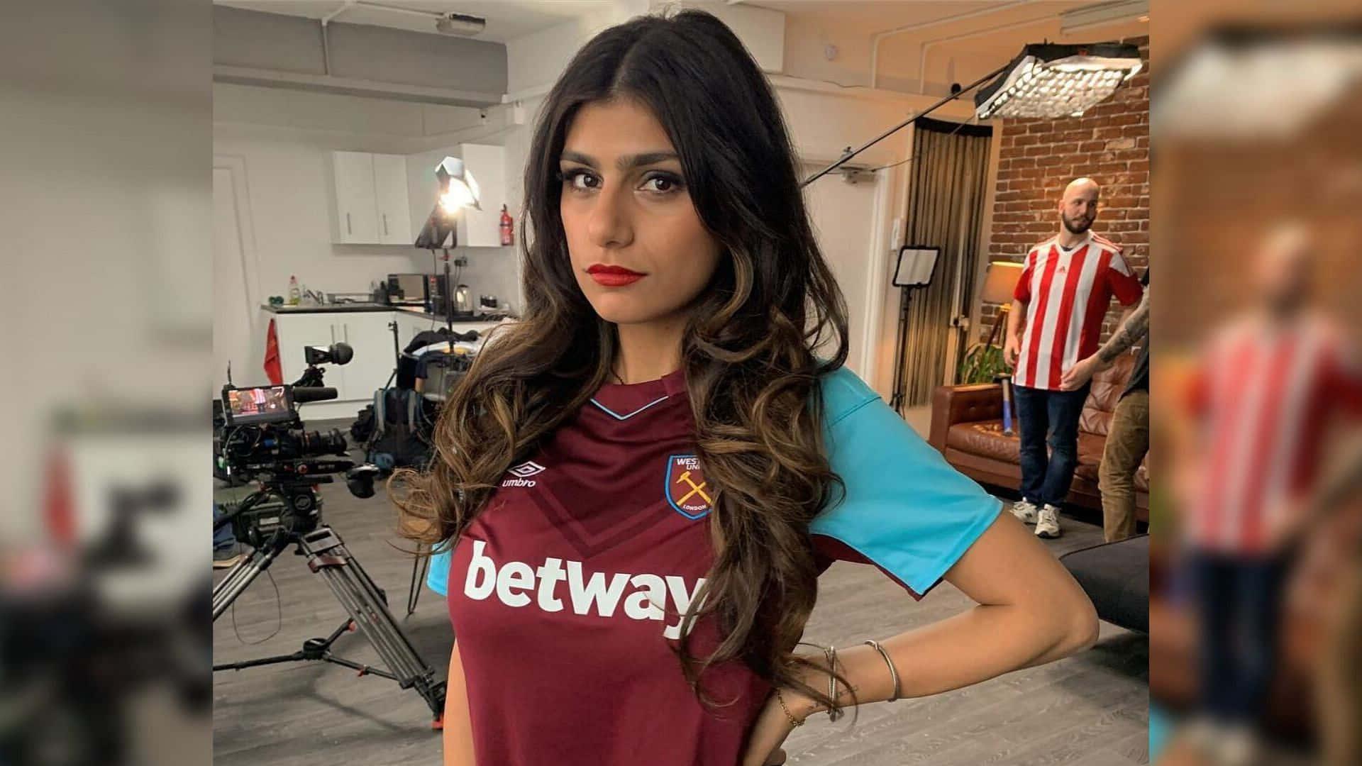 a woman in a soccer jersey posing for a camera — 1920x1080 wallpaper