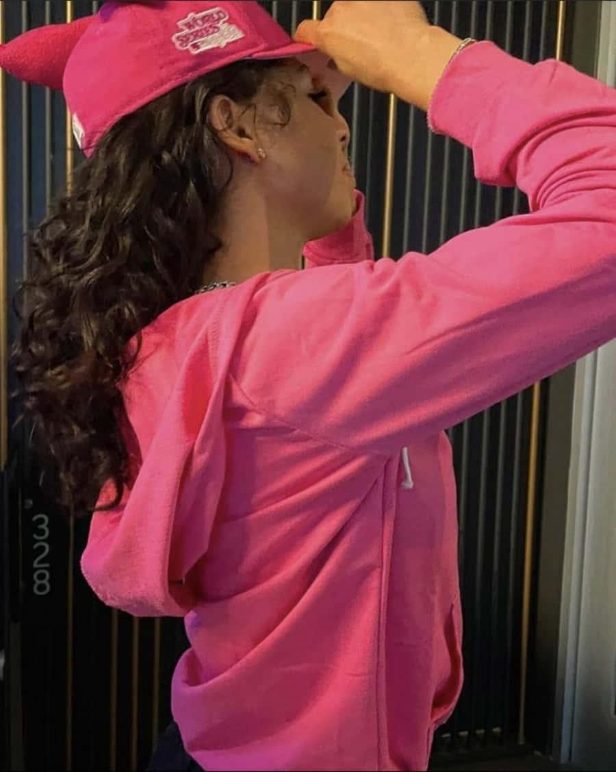 a woman wearing a pink hoodie and hat — 900x1127 wallpaper