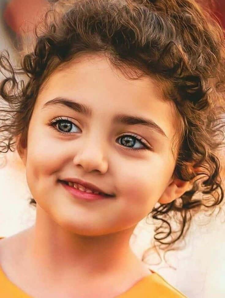 a young girl with curly hair is smiling — 735x976 wallpaper