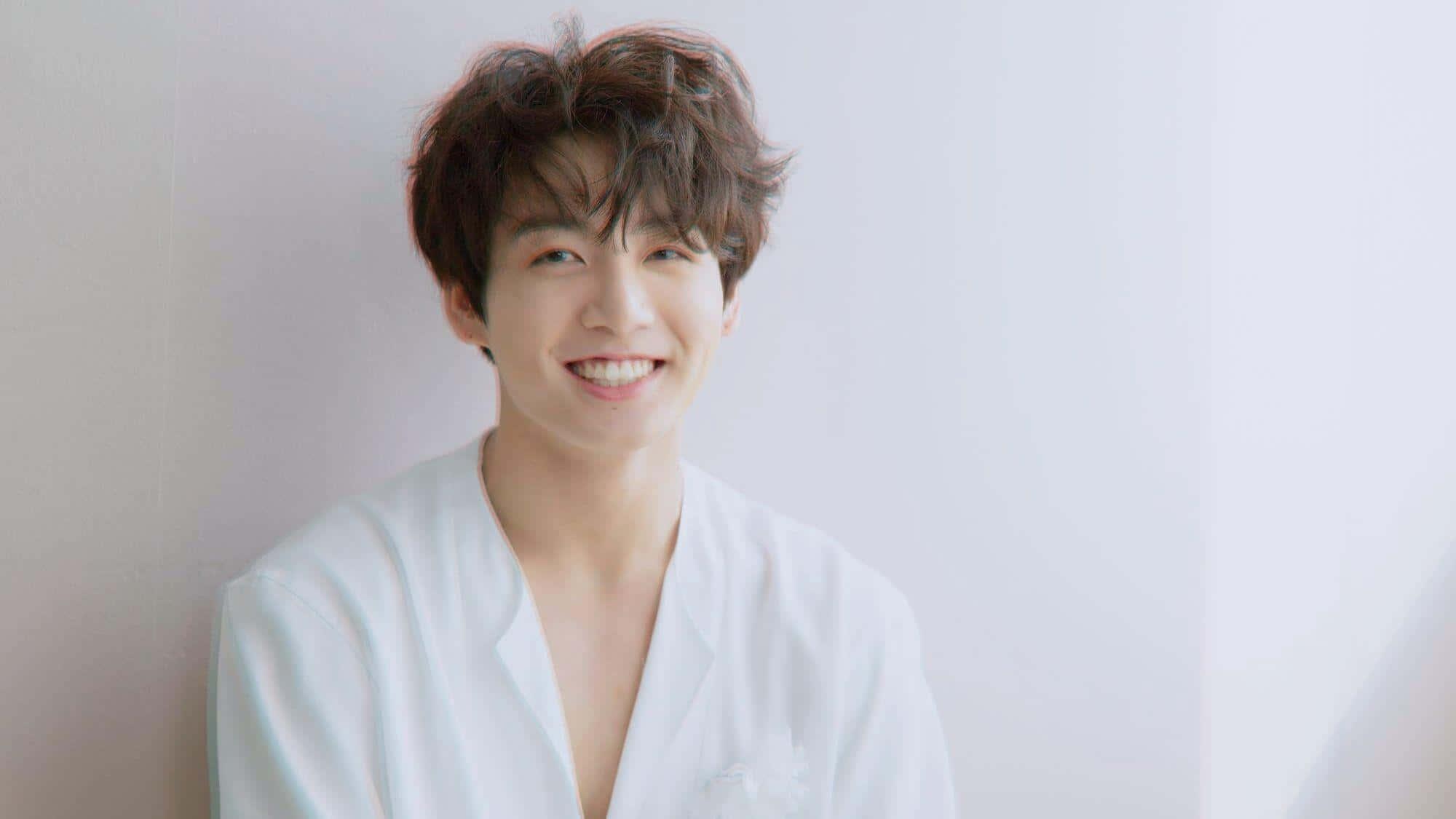a young man in a white robe smiling — 2000x1125 wallpaper