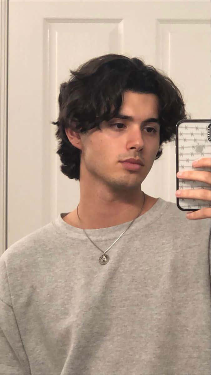 a young man taking a selfie in a mirror — 675x1200 wallpaper