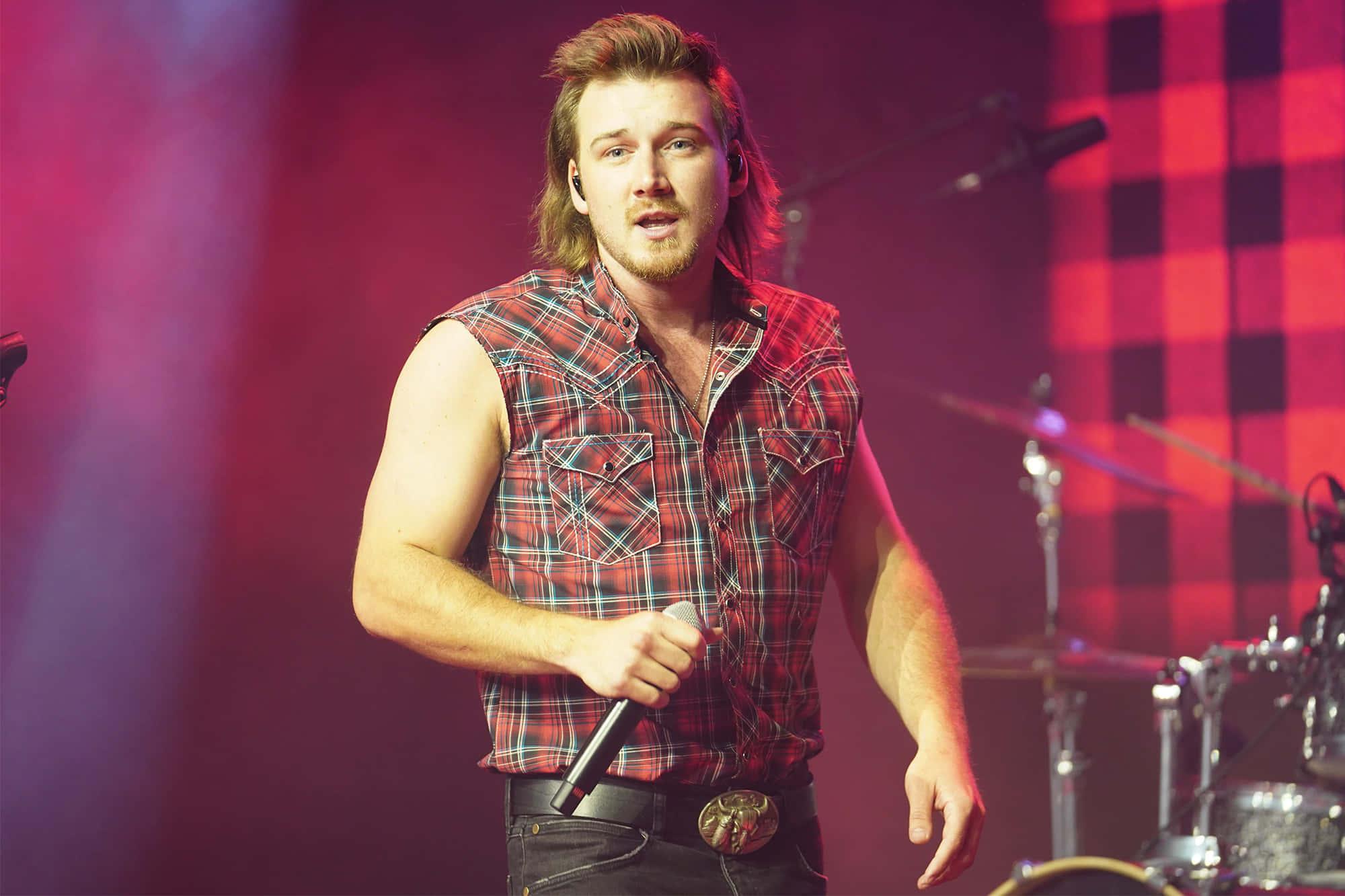 Country music sensation Morgan Wallen looks on with a cowboy hat, denim shirt and a guitar. — 2000x1333 wallpaper