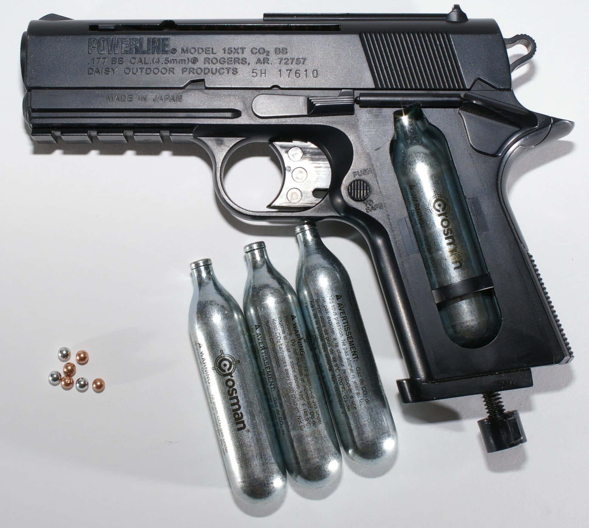 Description- An image of a black gun lying on an army-camo patterned blanket — 1977x1773 wallpaper