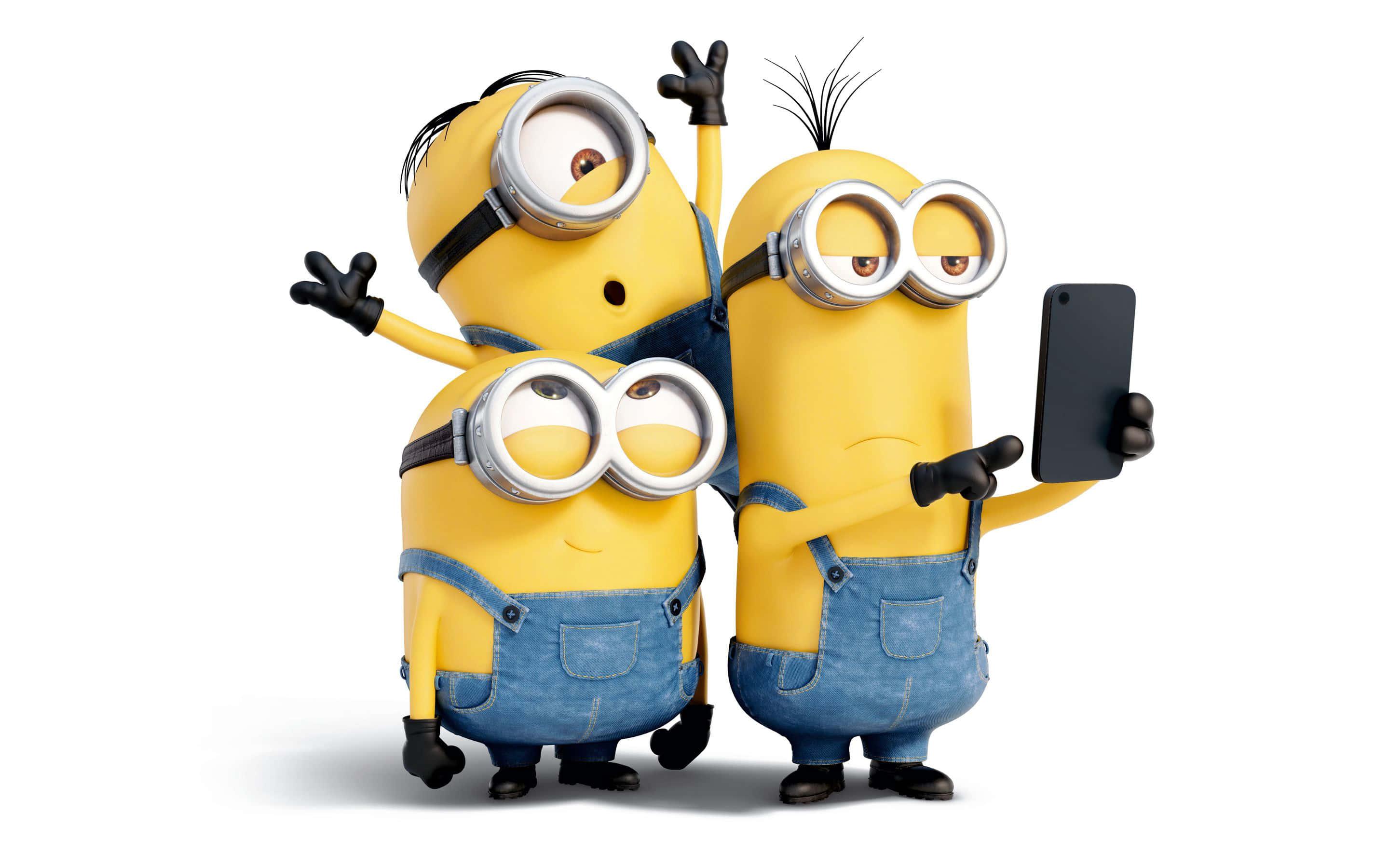 Description- Three Minions from the popular Despicable Me franchise standing side by side, dressed up in colorful overalls with smiling faces full of mischief. — 2880x1800 wallpaper