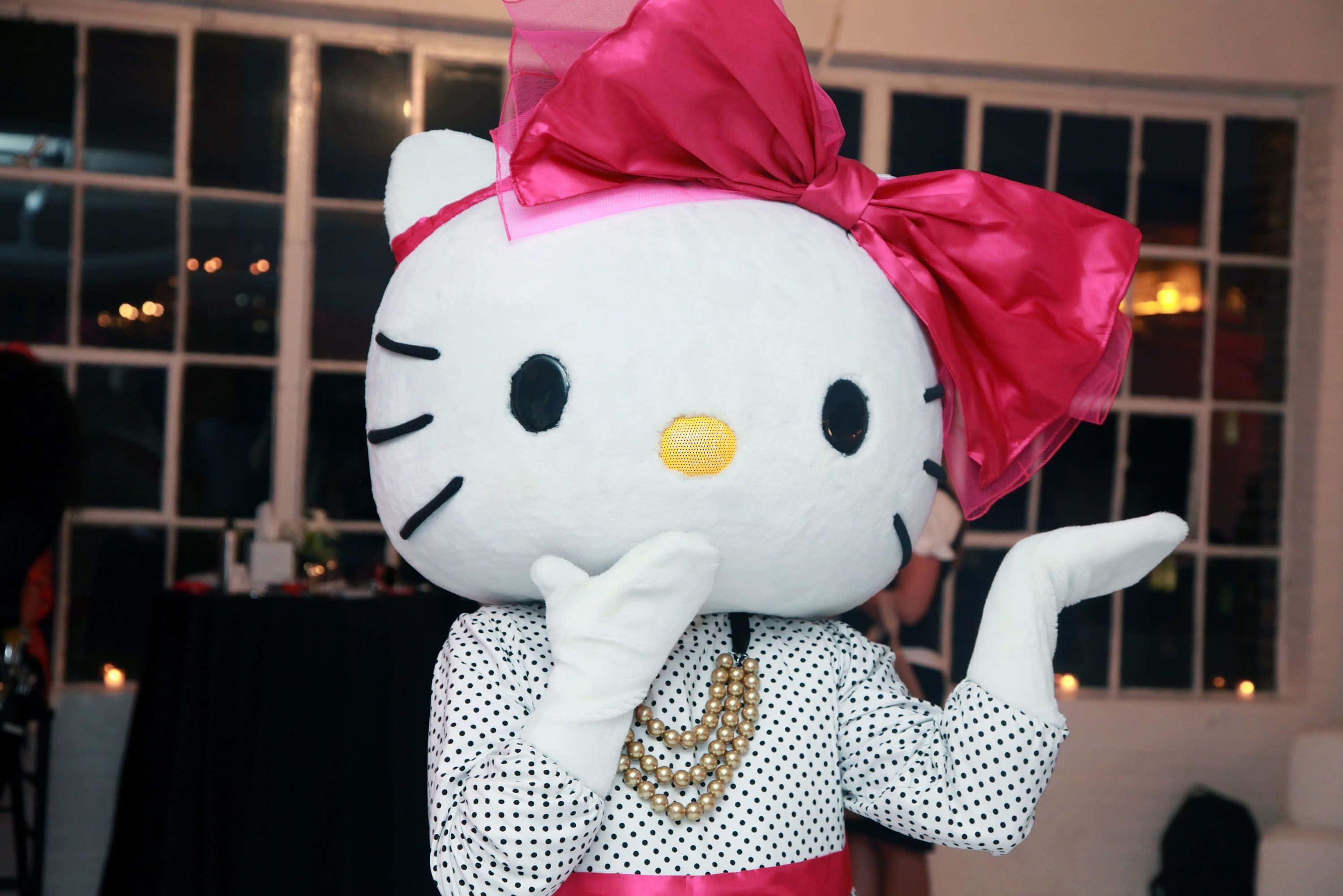 "Hello Kitty wearing a pink bow surrounded by pink and purple hearts"