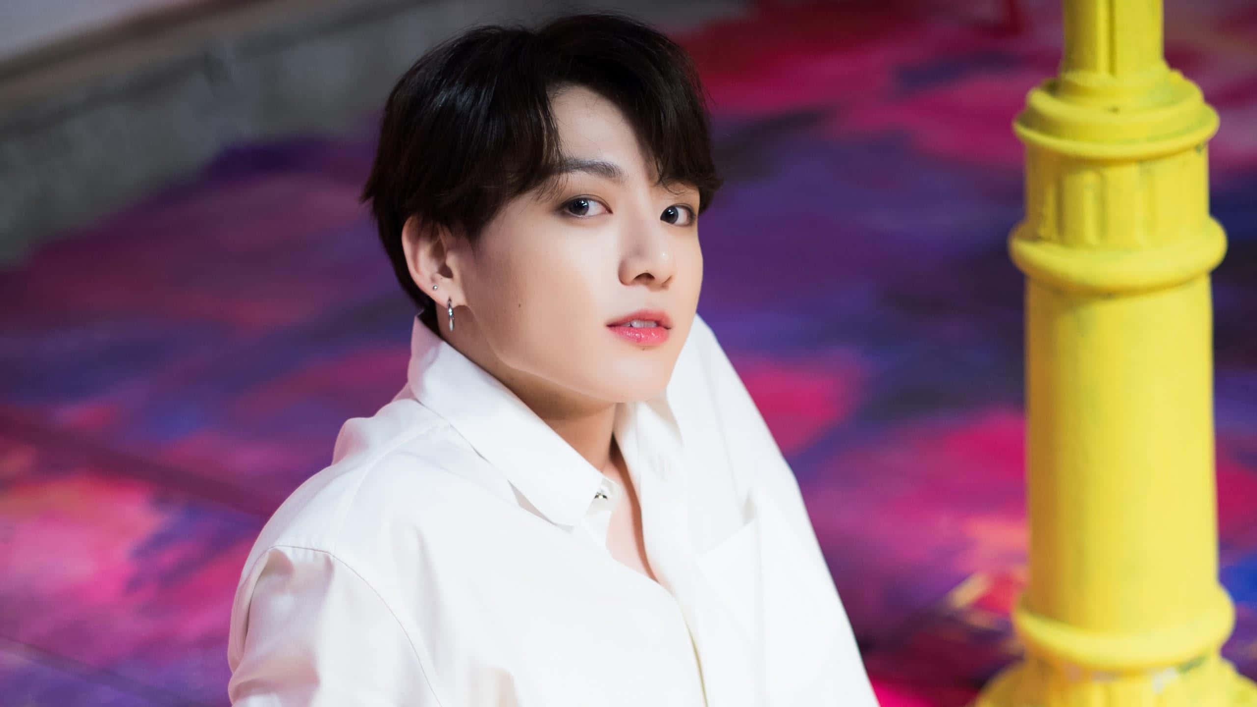 Jungkook of BTS smiles in a studio — 2560x1440 wallpaper