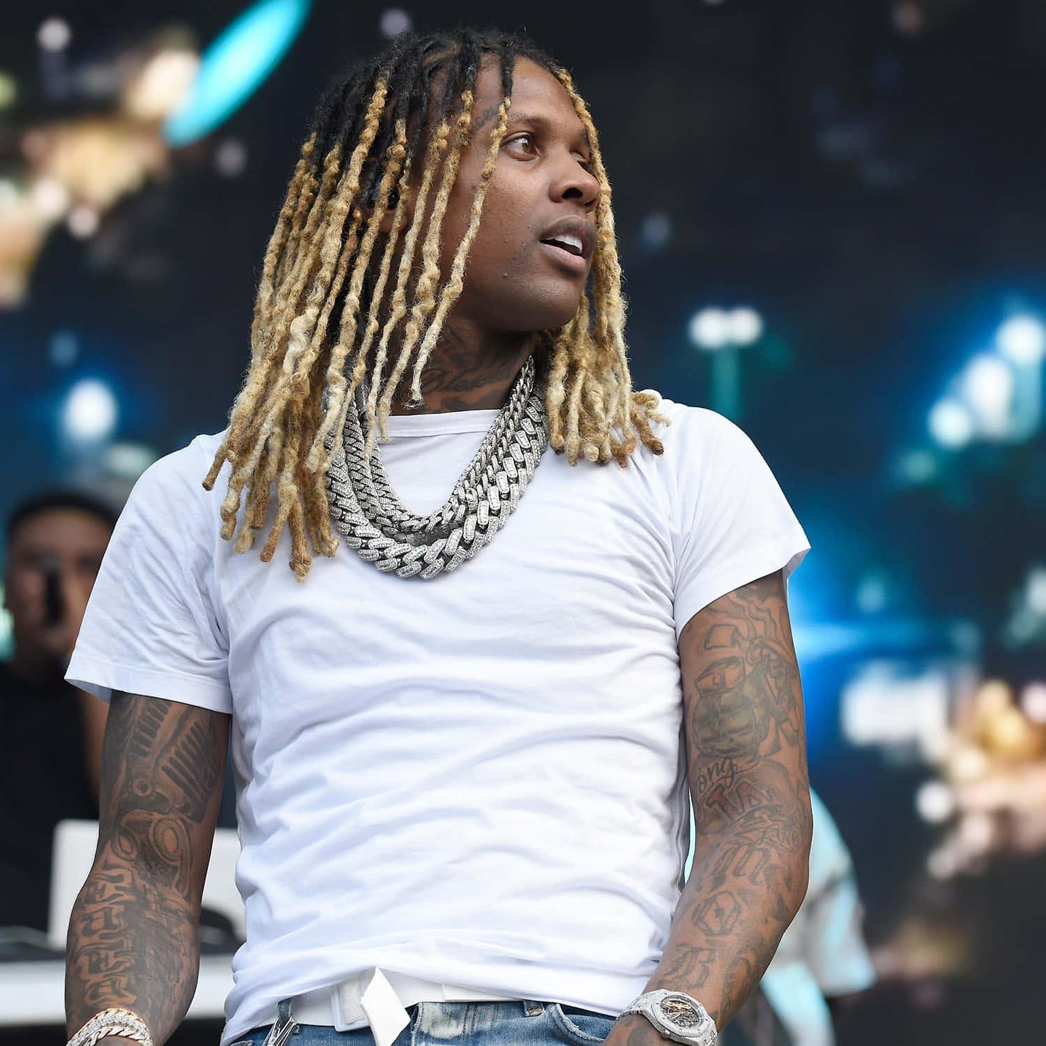Lil Durk striking a powerful pose in a colorful environment — 1500x1500 wallpaper
