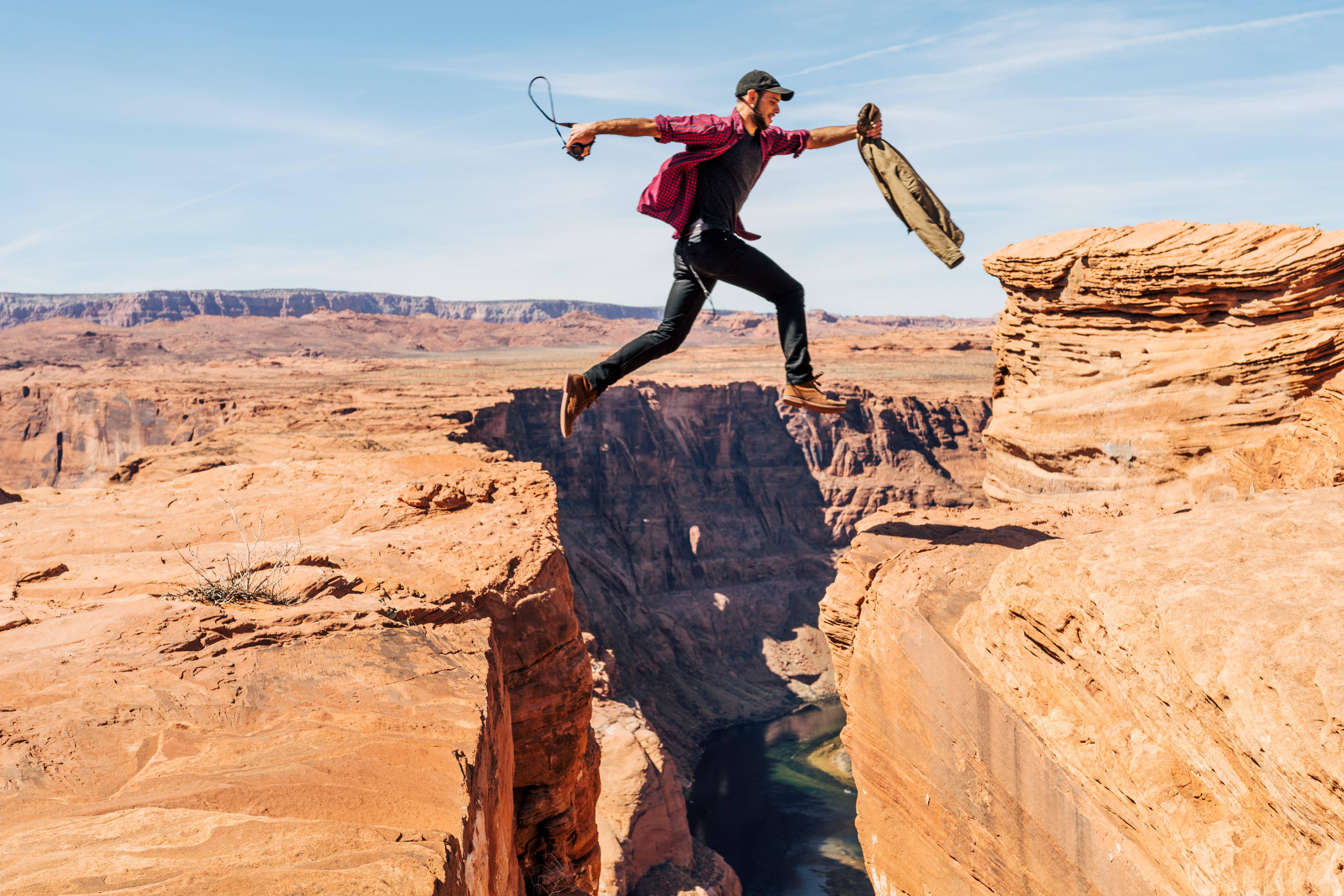 Man Jumping On Rock Formation — 6000x4000 wallpaper