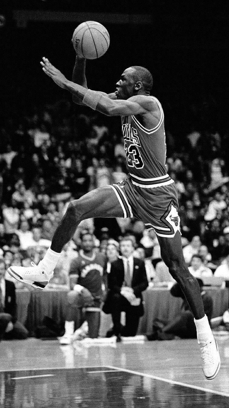 Michael Jordan taking flight in an iconic moment — 756x1344 wallpaper