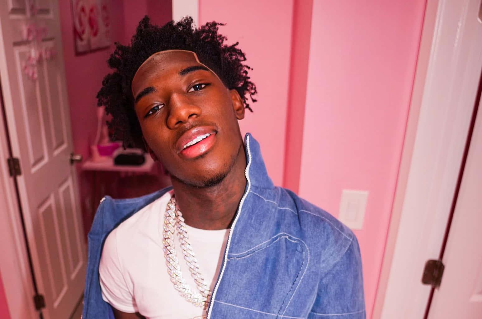 Rising star Nle Choppa striking a pose against a graffitied background — 1548x1024 wallpaper