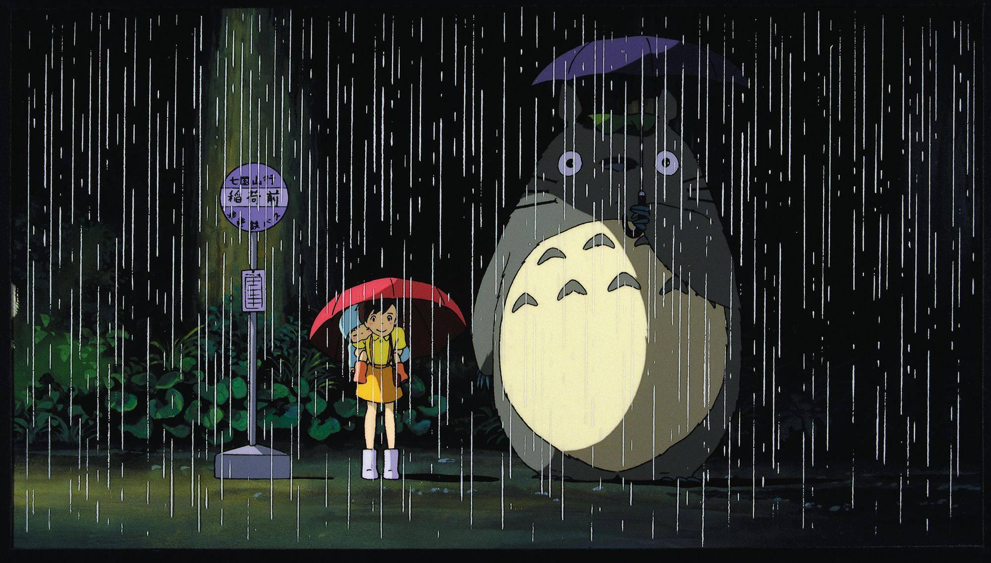 Satsuki and Mei embrace Totoro under the sheltering boughs of a magical tree during a rainstorm. — 2000x1137 wallpaper