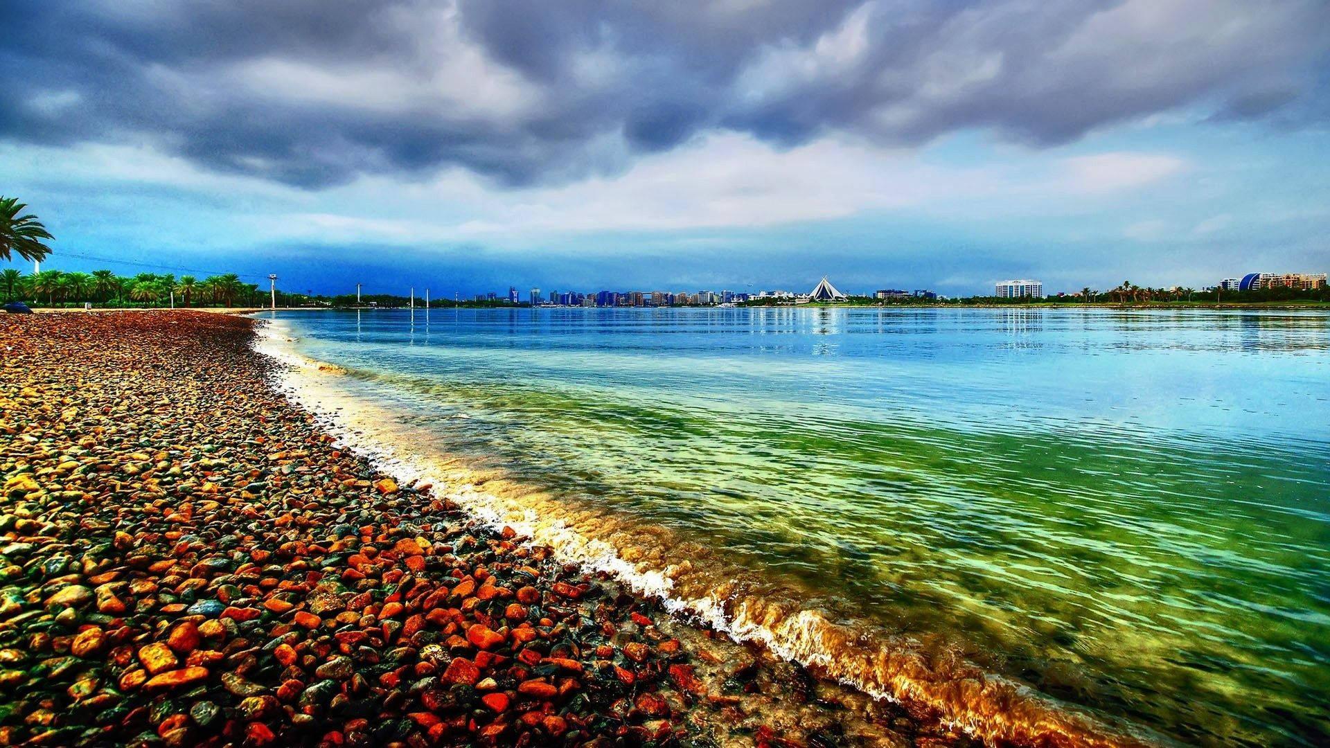 Seagrass between waves of colorful gravel along the shoreline of a beach. — 1920x1080 wallpaper