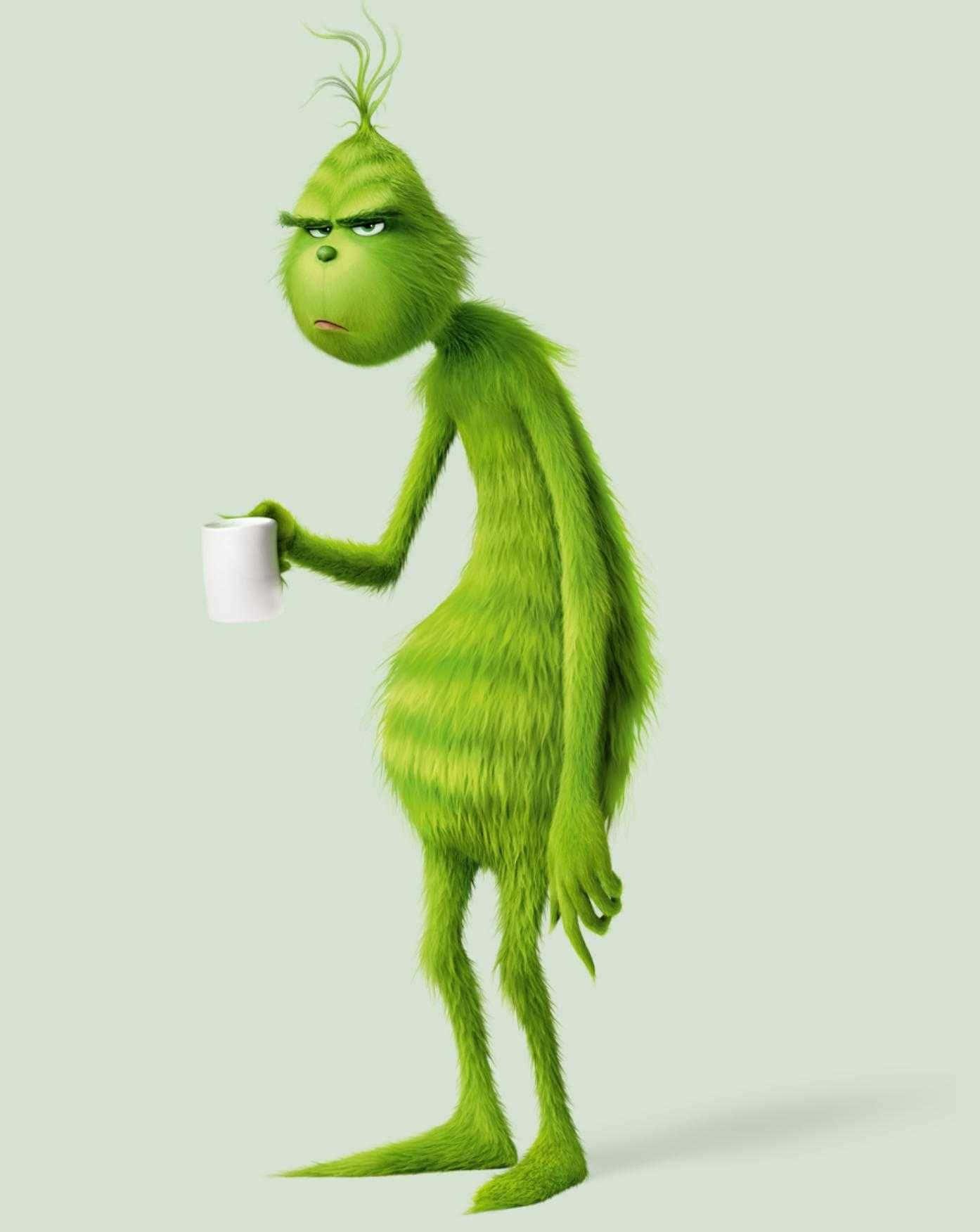 the grinch is holding a cup of coffee — 1394x1752 wallpaper