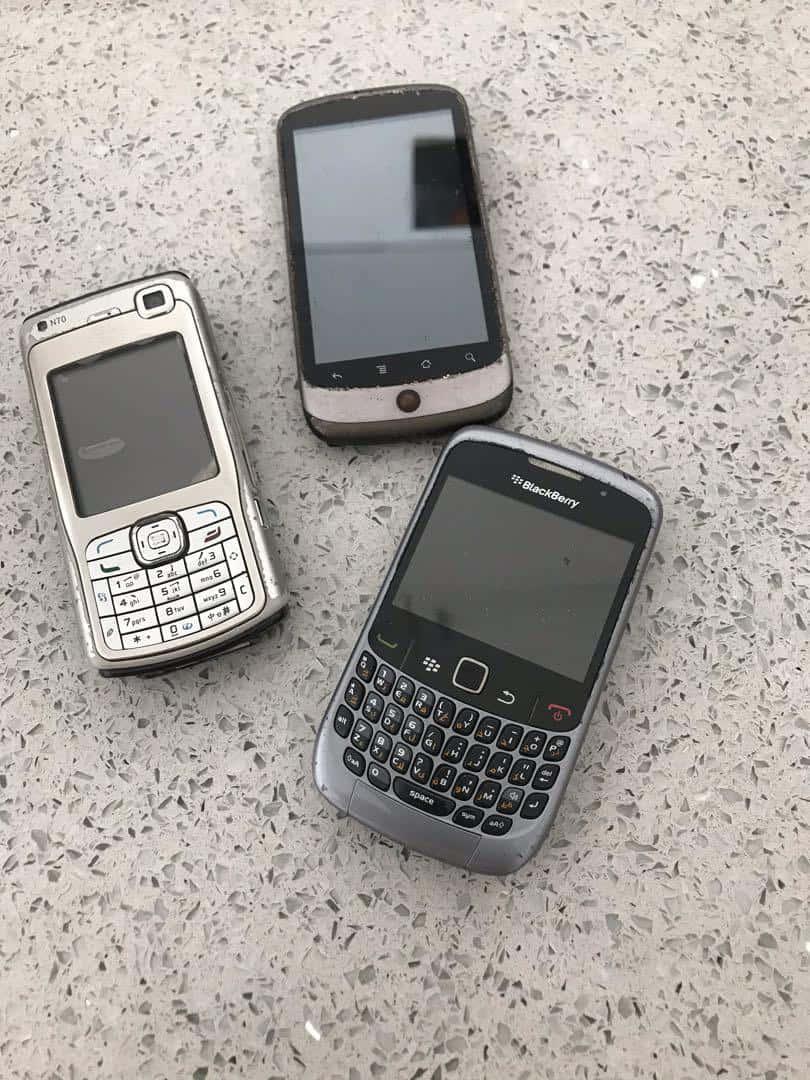 three blackberry phones on a concrete floor — 810x1080 wallpaper
