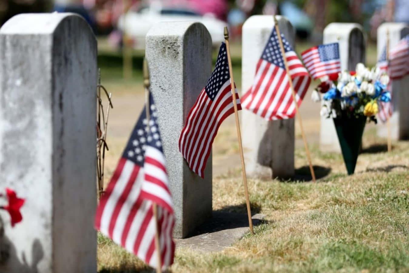 Two soldiers stand solemnly next to a Memorial Day wreath. — 1349x900 wallpaper