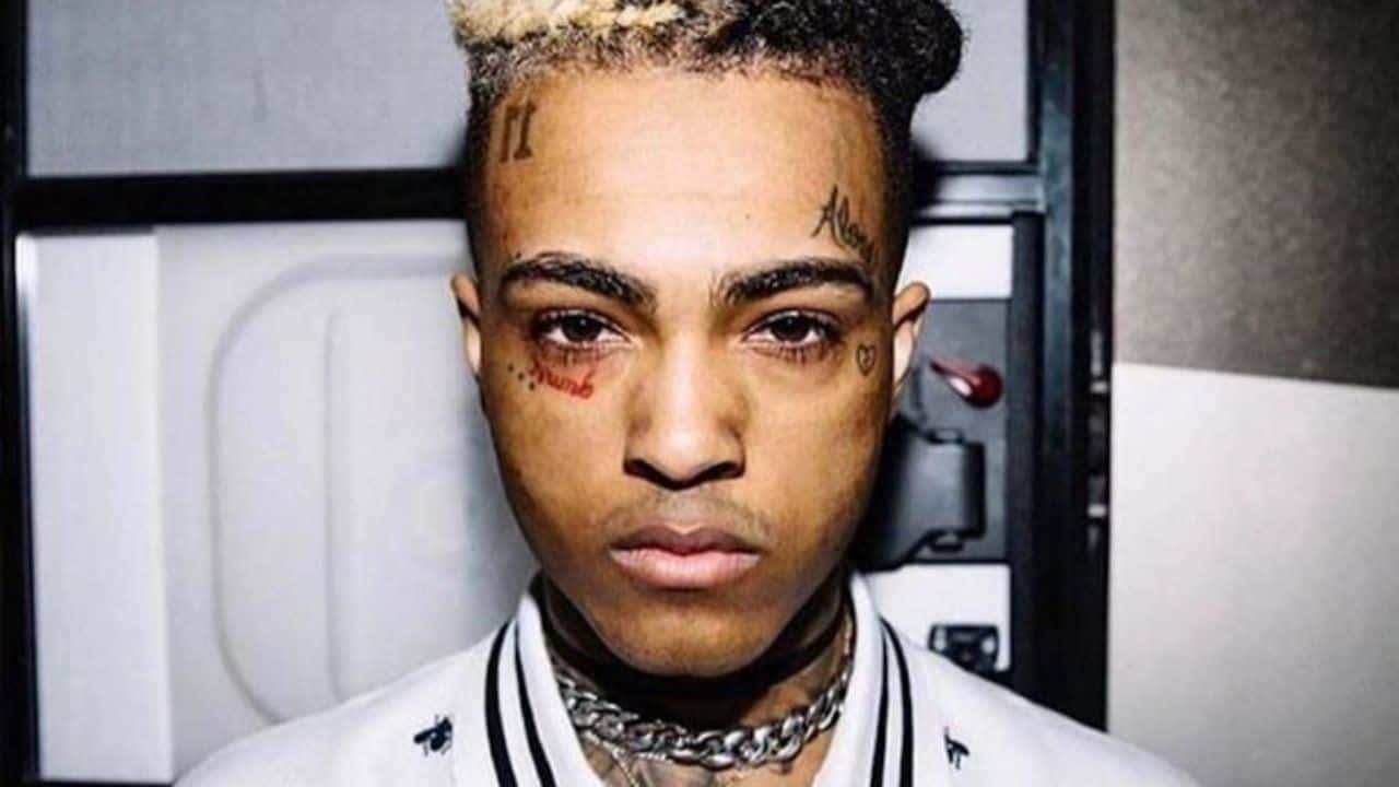 XXXTentacion smiles while wearing a long gold chain — 1280x720 wallpaper
